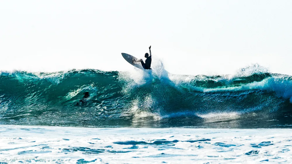 A surfer airborne above a breaking wave, El Zonte, El Salvador