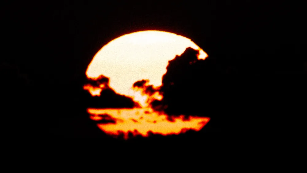 The sun setting behind dark clouds over the Caribbean, Utila, Honduras